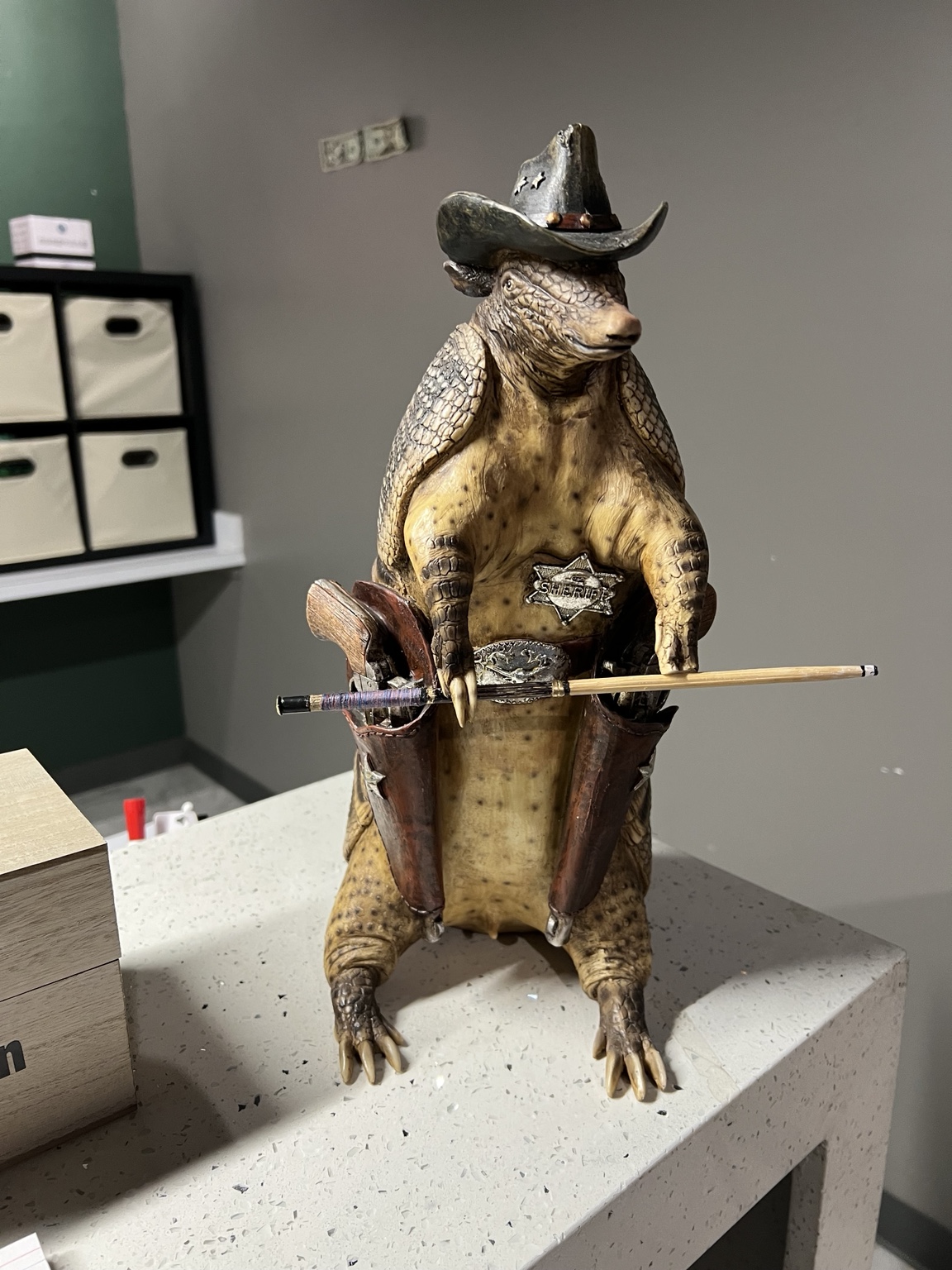 Pool-playing armadillo sculpture