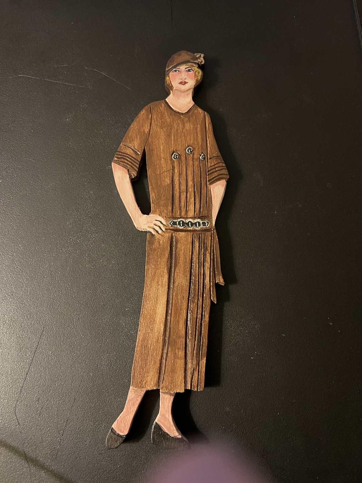 Painted fashion figure on a wooden women's restroom door