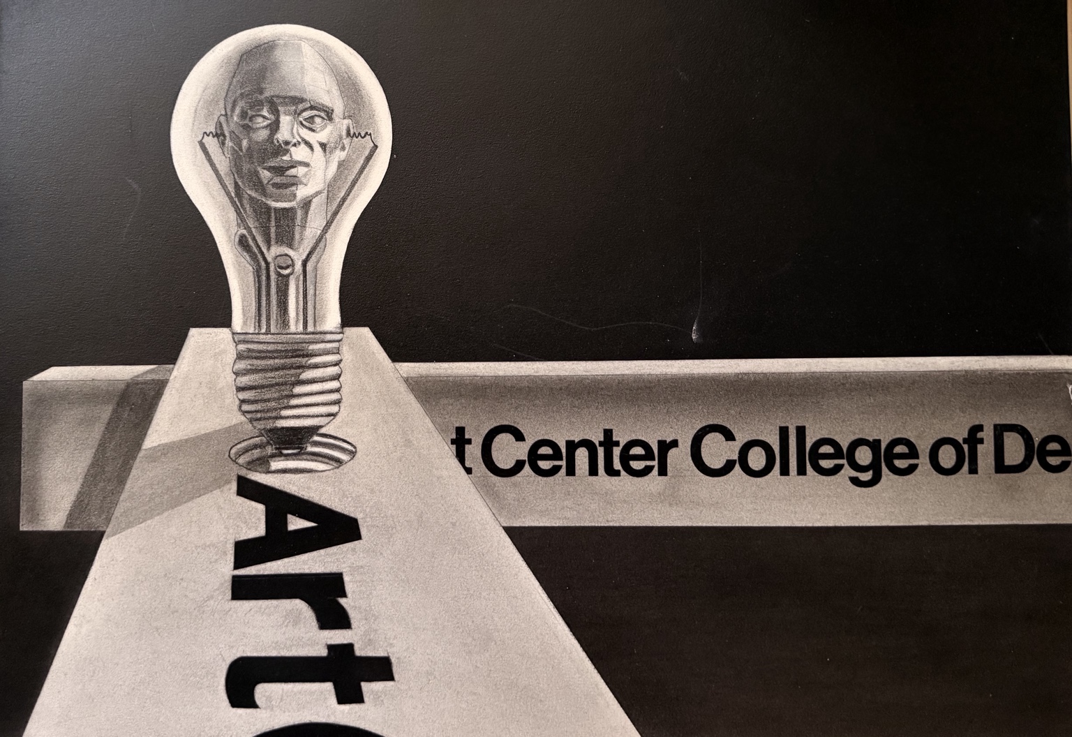 ArtCenter charcoal illustration showing a face inside a glowing light bulb